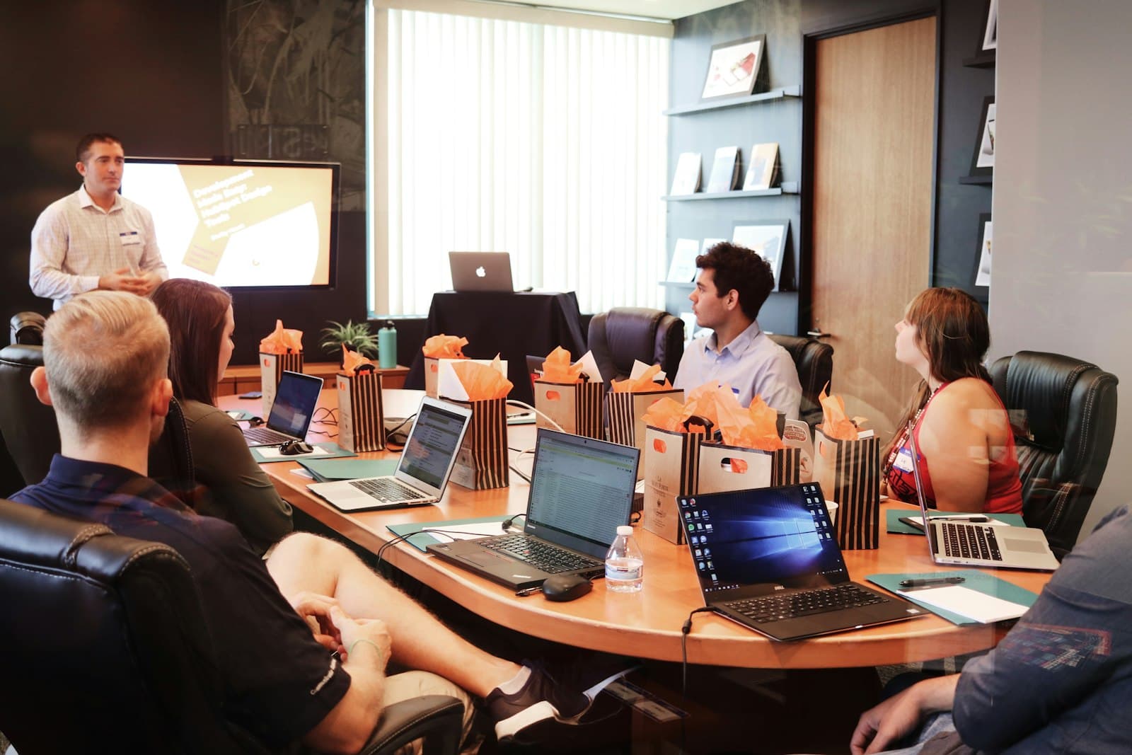 Business team working collaboratively in a modern office setting with computers and laptops